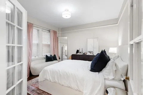 a bedroom with a bed and a large window with outer view