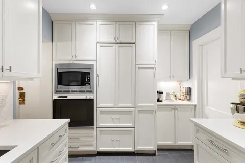 a kitchen with white cabinets and stainless steel appliances