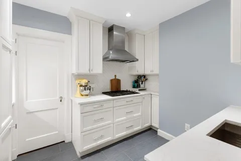 a kitchen with stainless steel appliances a sink a stove and cabinets
