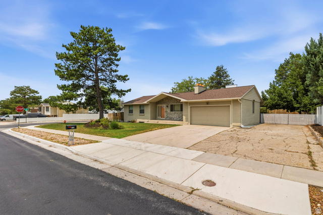 2693 Teal Way Sandy, UT 84093 - Photo 2 of 50 Ranch-style exterior featuring a stone facade accent, an attached garage, a paved driveway, and mature landscaping