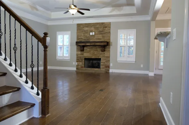 wooden floor fireplace and windows in an empty room