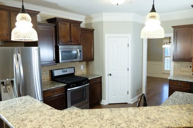 a kitchen with granite countertop a refrigerator and a sink