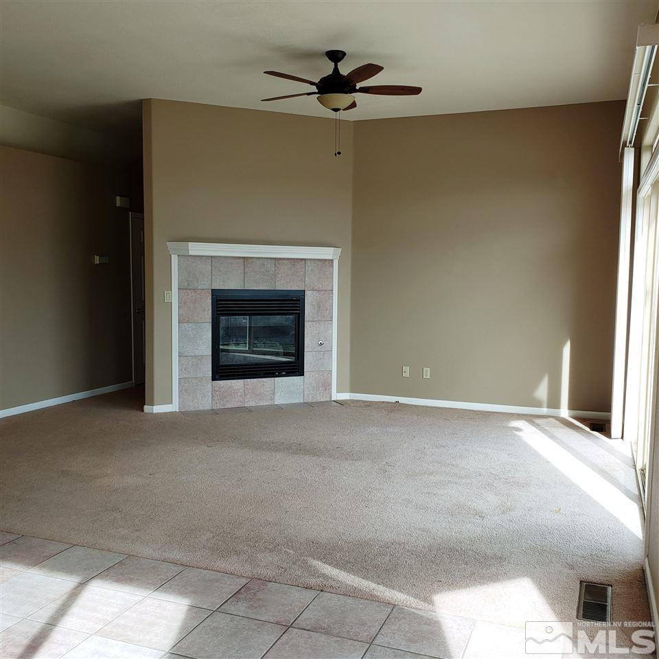 986 University Place Reno, NV 89512 - Photo 8 of 25 an empty room with a fireplace and fan