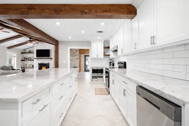 a large kitchen with stainless steel appliances kitchen island granite countertop a sink and cabinets
