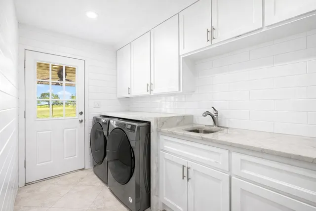 a utility room with sink dryer and washer