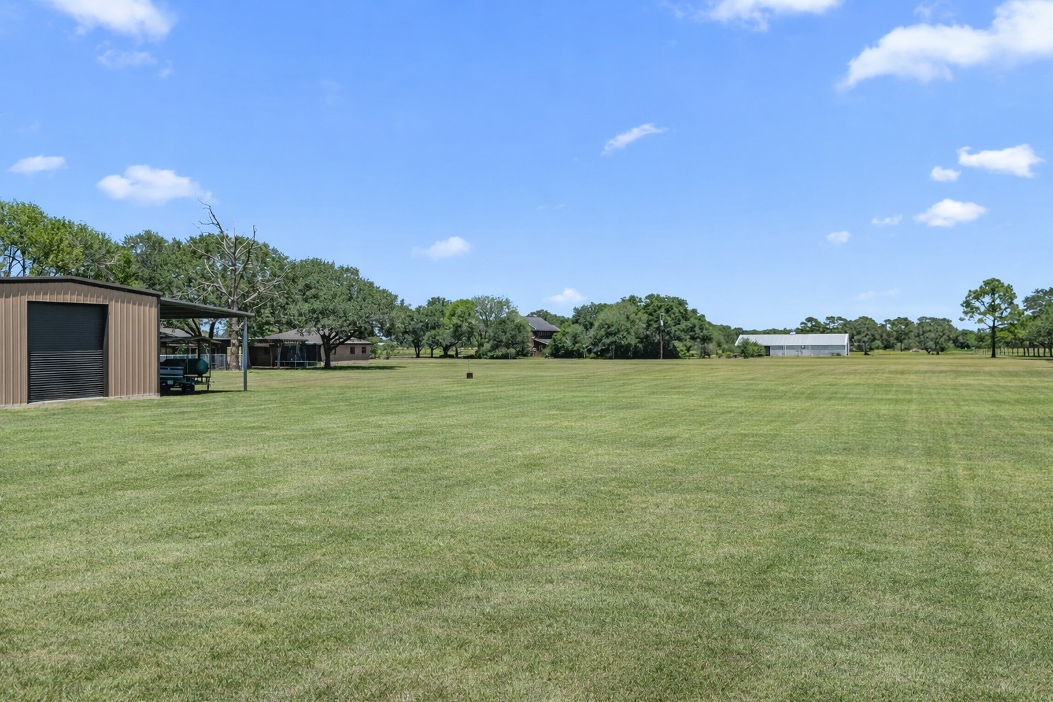 3148 FM 333 Road Garwood, TX 77442 - Photo 37 of 39 a backyard of a house with lots of green space and fog