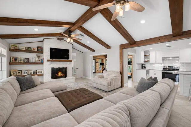 a living room with furniture a fireplace and a flat screen tv