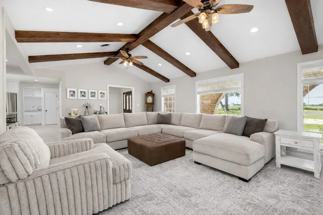 a living room with furniture and a ceiling fan