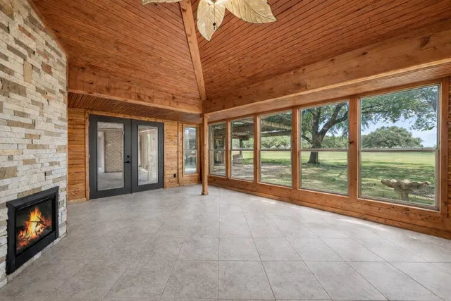 a view of an empty room with a fireplace and a window