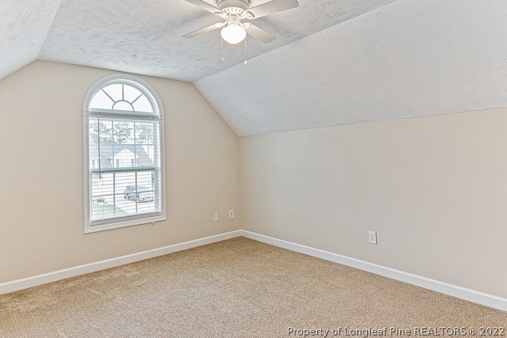 75 Hayden Lane Cameron, NC 28326 - Photo 23 of 35 an empty room with a chandelier fan and windows