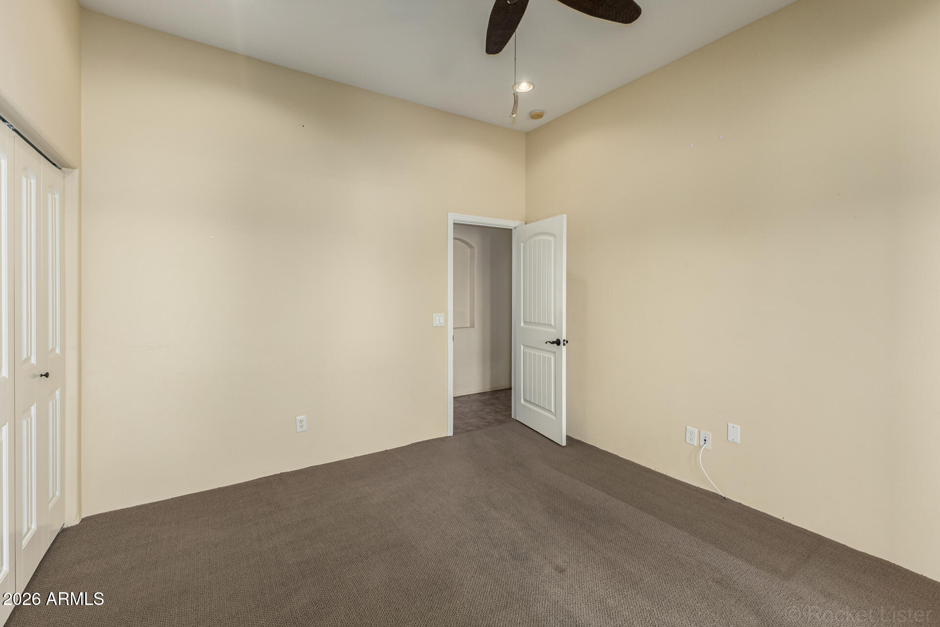 6033 East Lone Mountain Road Cave Creek, AZ 85331 - Photo 45 of 77 an empty room with a ceiling fan and carpet