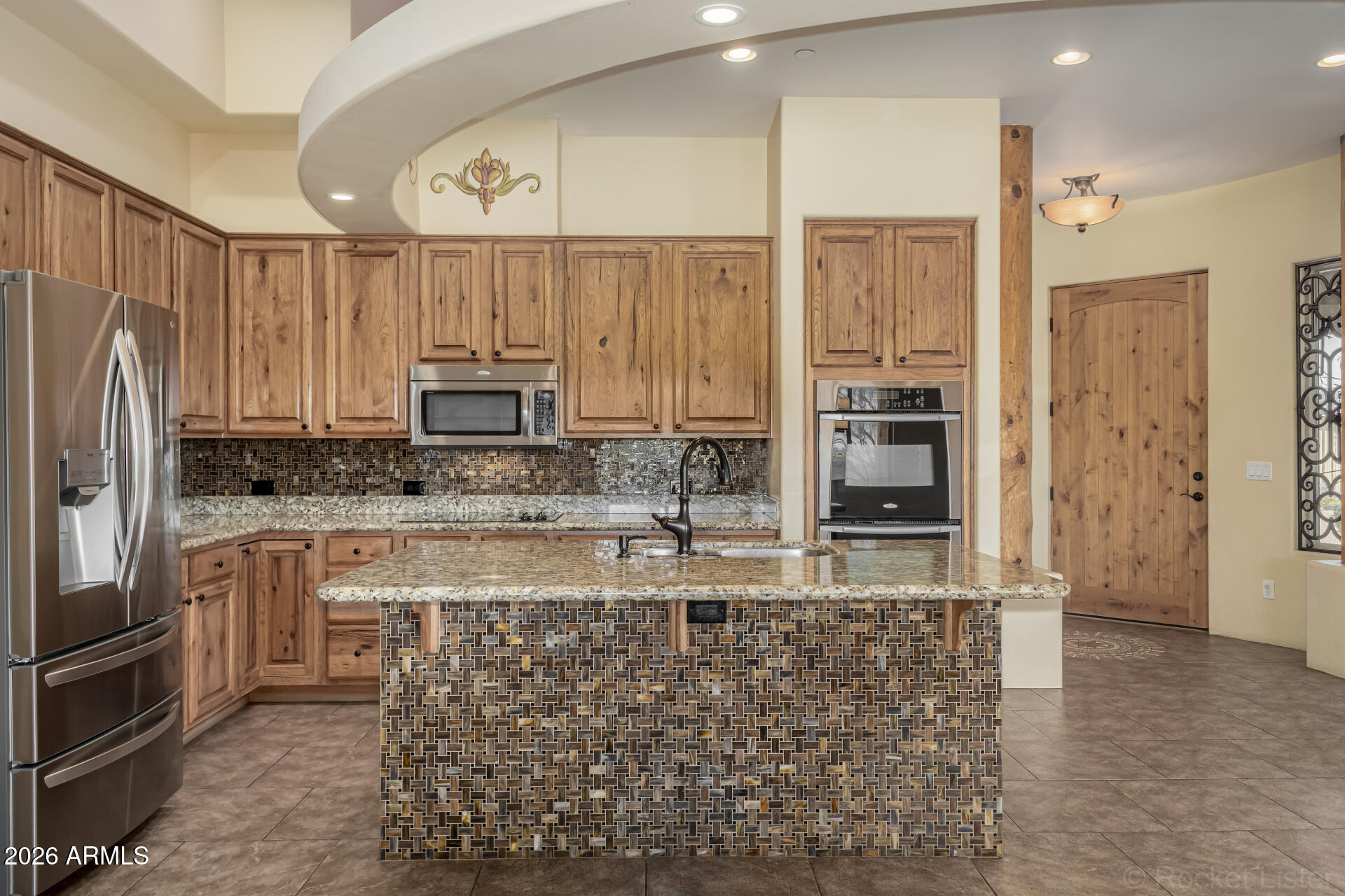6033 East Lone Mountain Road Cave Creek, AZ 85331 - Photo 5 of 77 a kitchen with stainless steel appliances granite countertop a refrigerator a stove and white cabinets with wooden floor