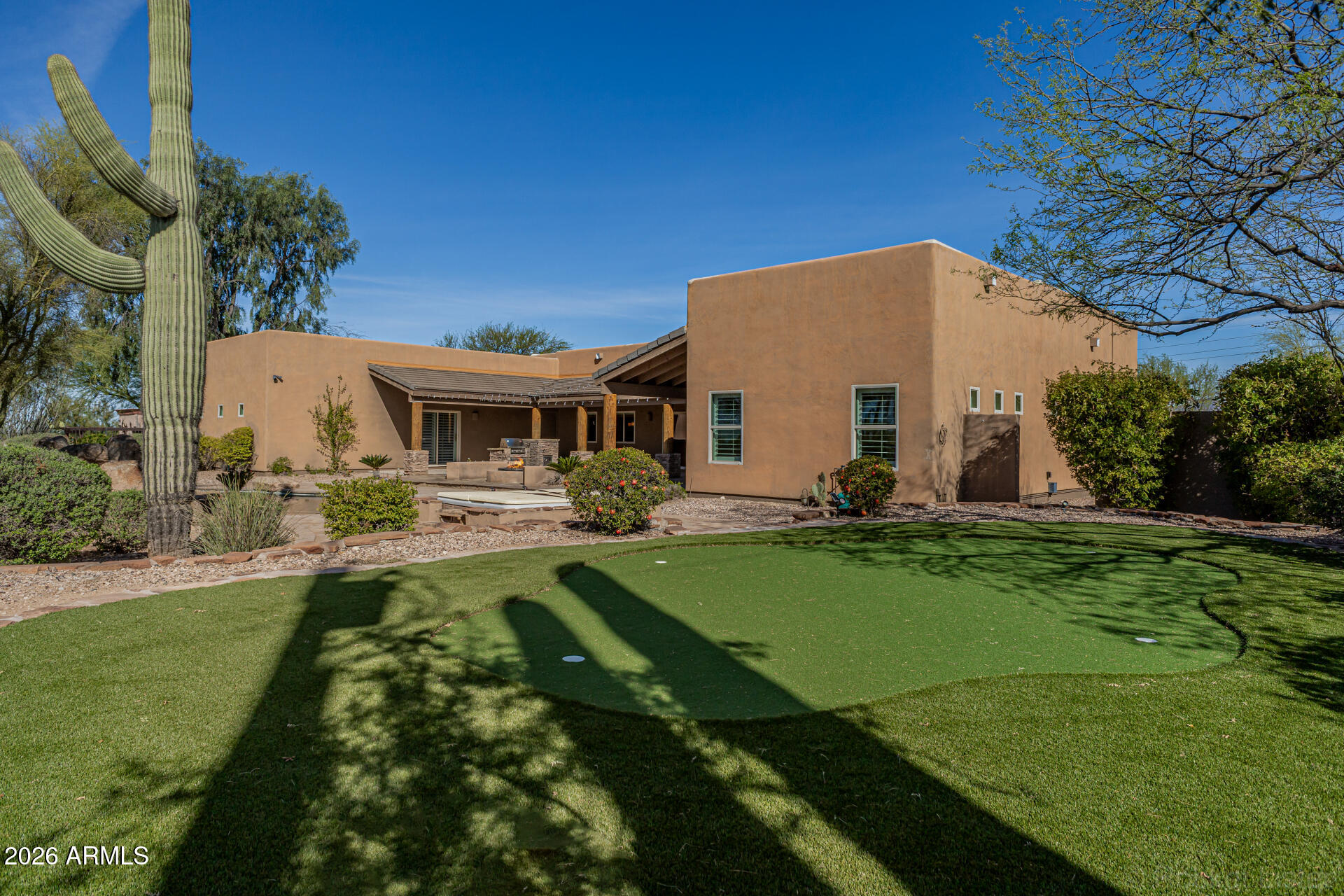 6033 East Lone Mountain Road Cave Creek, AZ 85331 - Photo 58 of 77 a view of a white house with a yard table and chairs