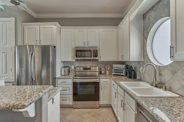 a view of a patio with table and chairs with plants and wooden fence