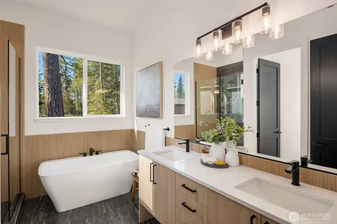 a bathroom with a tub sink and mirror