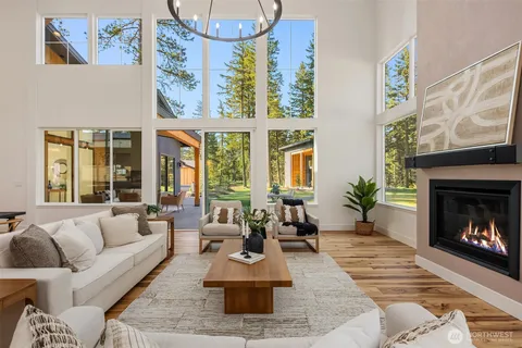 a living room with furniture large window and fireplace
