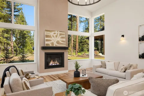 a living room with furniture a fireplace and a large window