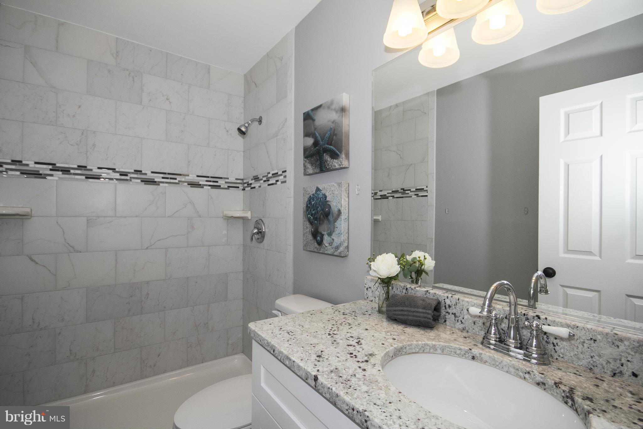 47 Robin Ridge Court Baltimore, MD 21234 - Photo 26 of 30 a bathroom with a granite countertop sink a toilet and shower