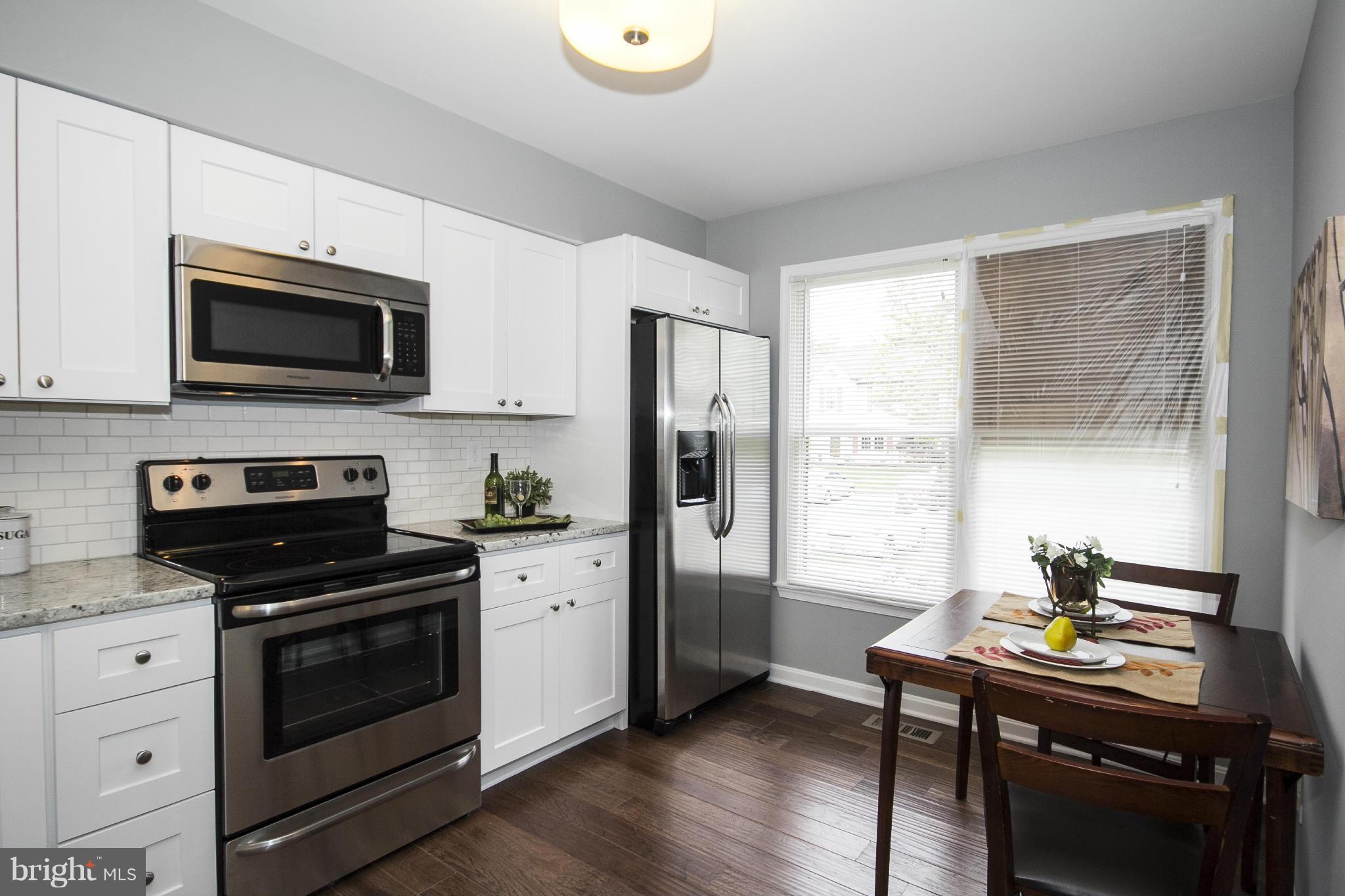 47 Robin Ridge Court Baltimore, MD 21234 - Photo 6 of 30 a kitchen with cabinets stainless steel appliances and wooden floor