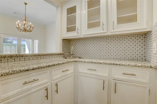 a bathroom with a granite countertop sink a mirror and cabinets