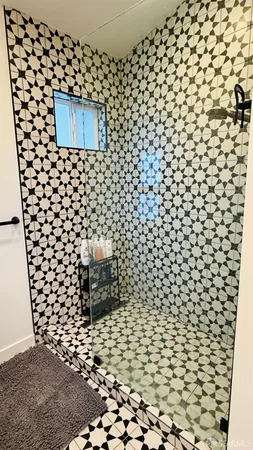 a view of an empty room with wooden floor and fan