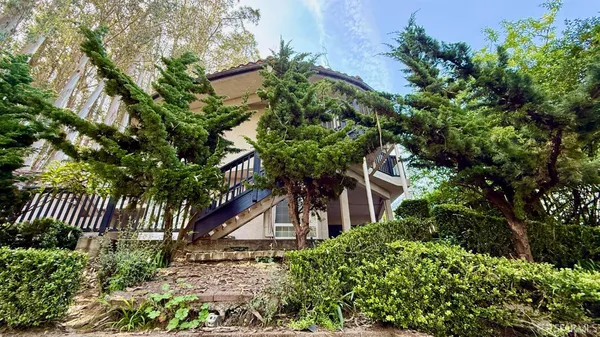 a front view of a house with a tree