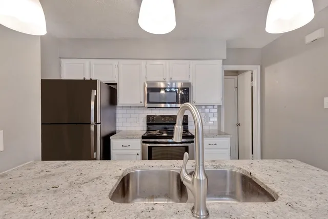 a kitchen with a refrigerator sink and stove