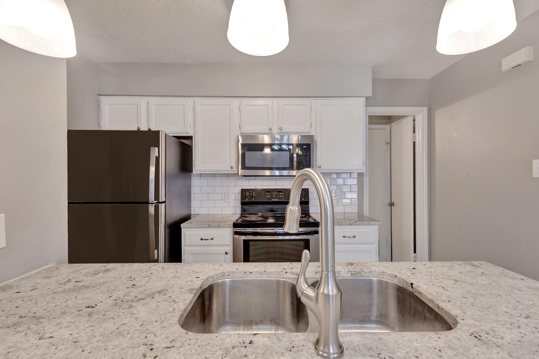 2402 Sycamore Avenue, Unit D4 Huntsville, TX 77340 - Photo 14 of 19 a kitchen with a refrigerator sink and stove