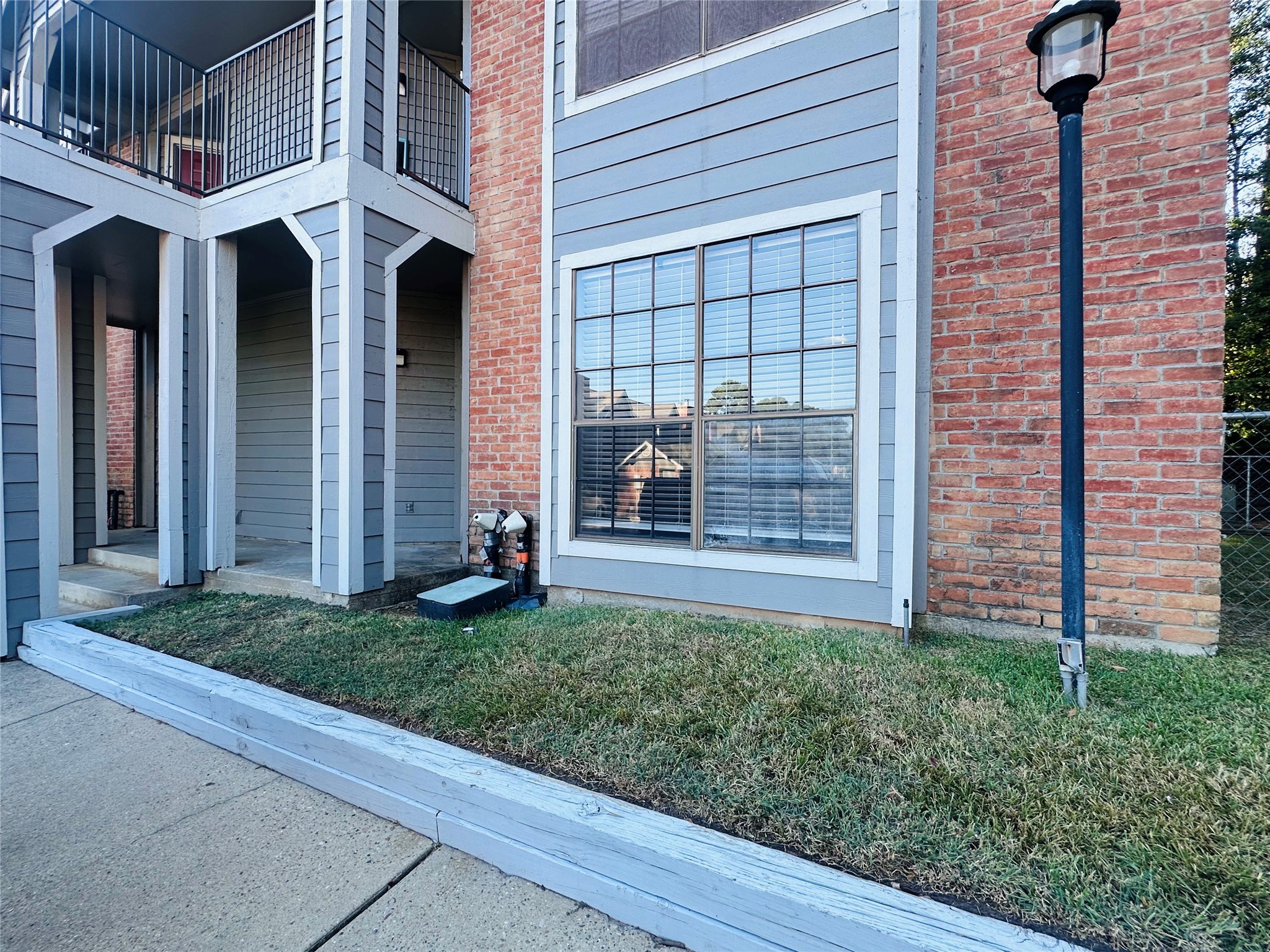 2402 Sycamore Avenue, Unit D4 Huntsville, TX 77340 - Photo 2 of 19 a view of a house with brick walls and a yard with plants