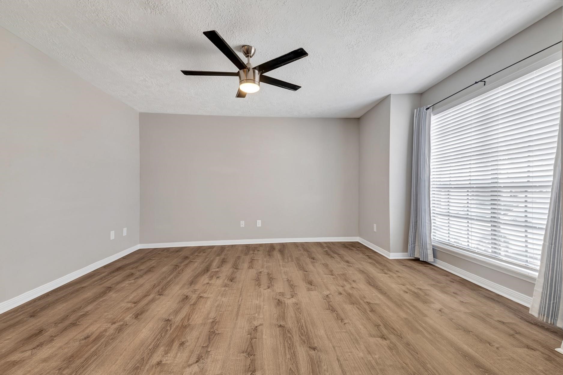 2402 Sycamore Avenue, Unit D4 Huntsville, TX 77340 - Photo 7 of 19 wooden floor in an empty room with a window