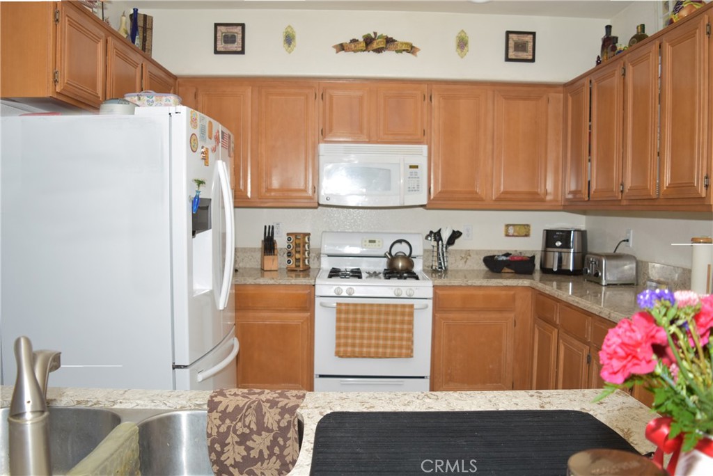 1665 Ravenswood Road Beaumont, CA 92223 - Photo 14 of 41 a kitchen with stainless steel appliances granite countertop a sink stove and cabinets
