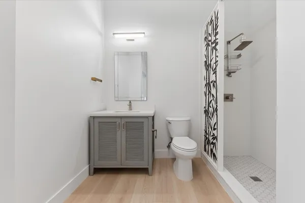 a bathroom with a sink a toilet and shower