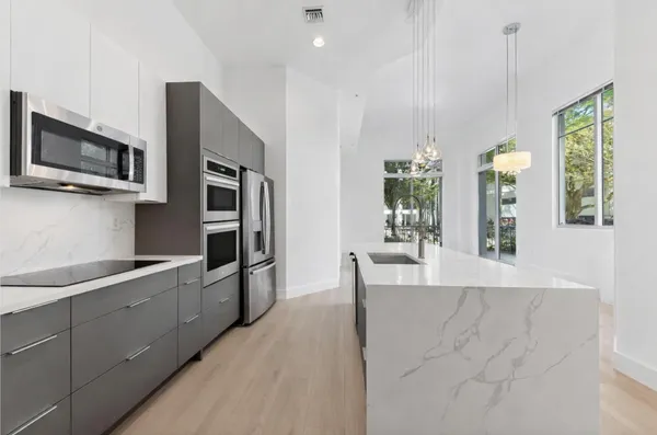 a kitchen with stainless steel appliances granite countertop a refrigerator and microwave