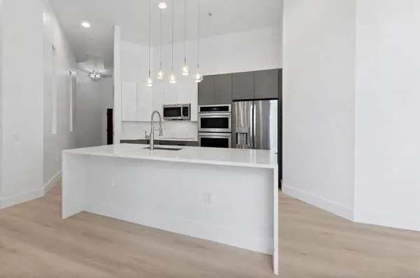a kitchen with kitchen island a refrigerator and a sink