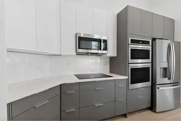 a kitchen with stainless steel appliances granite countertop a refrigerator and a microwave