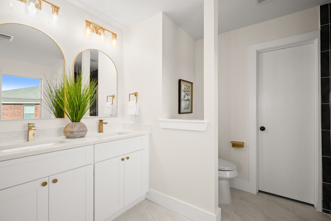 13625 Coomer Path Pflugerville, TX 78660 - Photo 11 of 22 a bathroom with a toilet sink and mirror