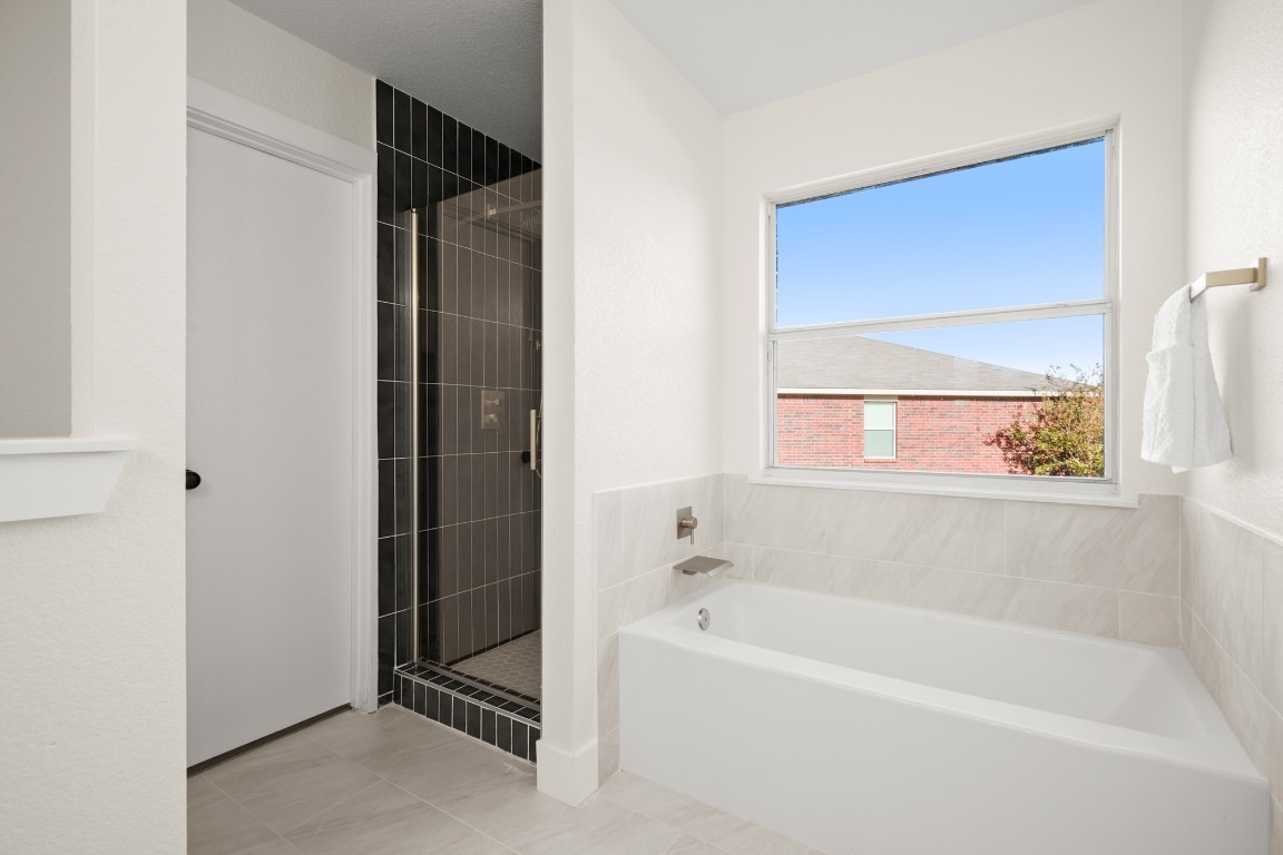 13625 Coomer Path Pflugerville, TX 78660 - Photo 12 of 22 a bathroom with a bathtub and a shower