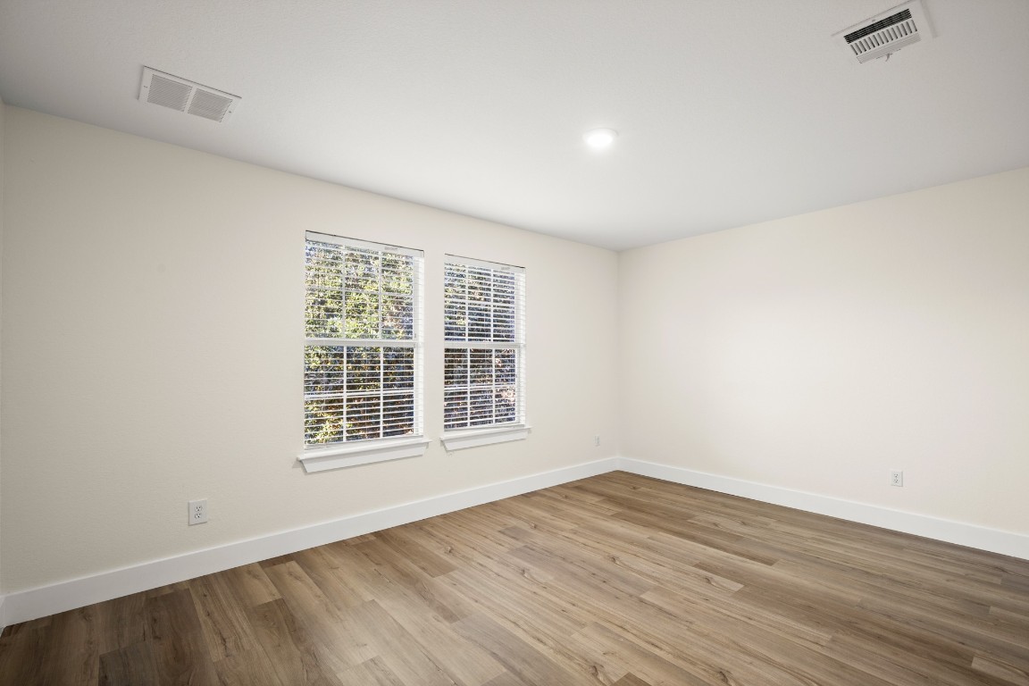 13625 Coomer Path Pflugerville, TX 78660 - Photo 16 of 22 an empty room with wooden floor and windows