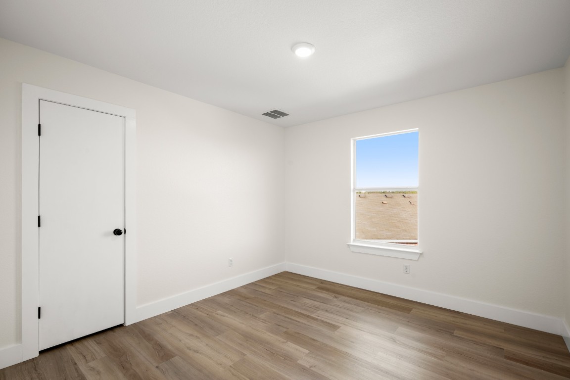 13625 Coomer Path Pflugerville, TX 78660 - Photo 17 of 22 an empty room with wooden floor and windows