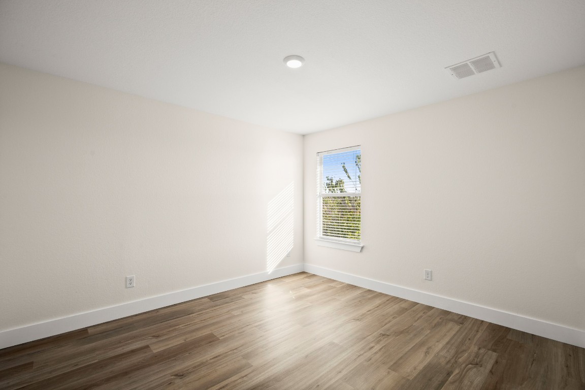 13625 Coomer Path Pflugerville, TX 78660 - Photo 18 of 22 an empty room with wooden floor and windows