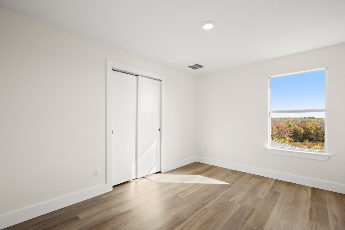 13625 Coomer Path Pflugerville, TX 78660 - Photo 19 of 22 an empty room with wooden floor and windows