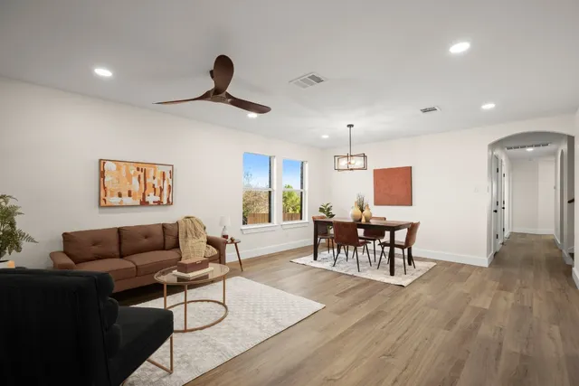 a living room with furniture and a wooden floor