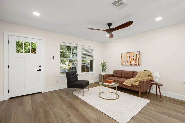 a living room with furniture and wooden floor