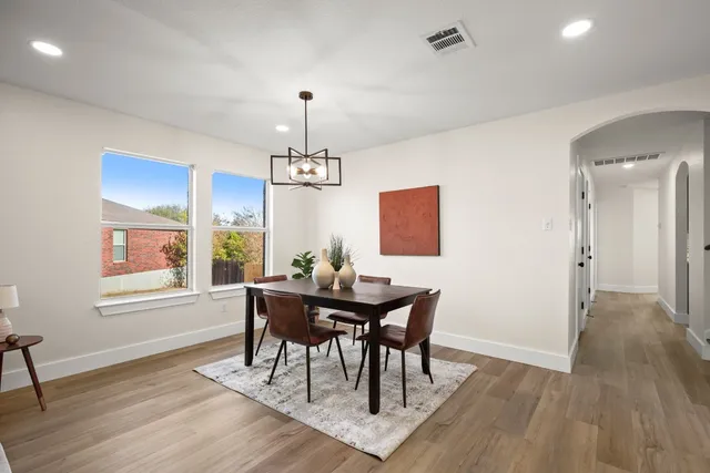 a view of a dining room with furniture a chandelier and wooden floor