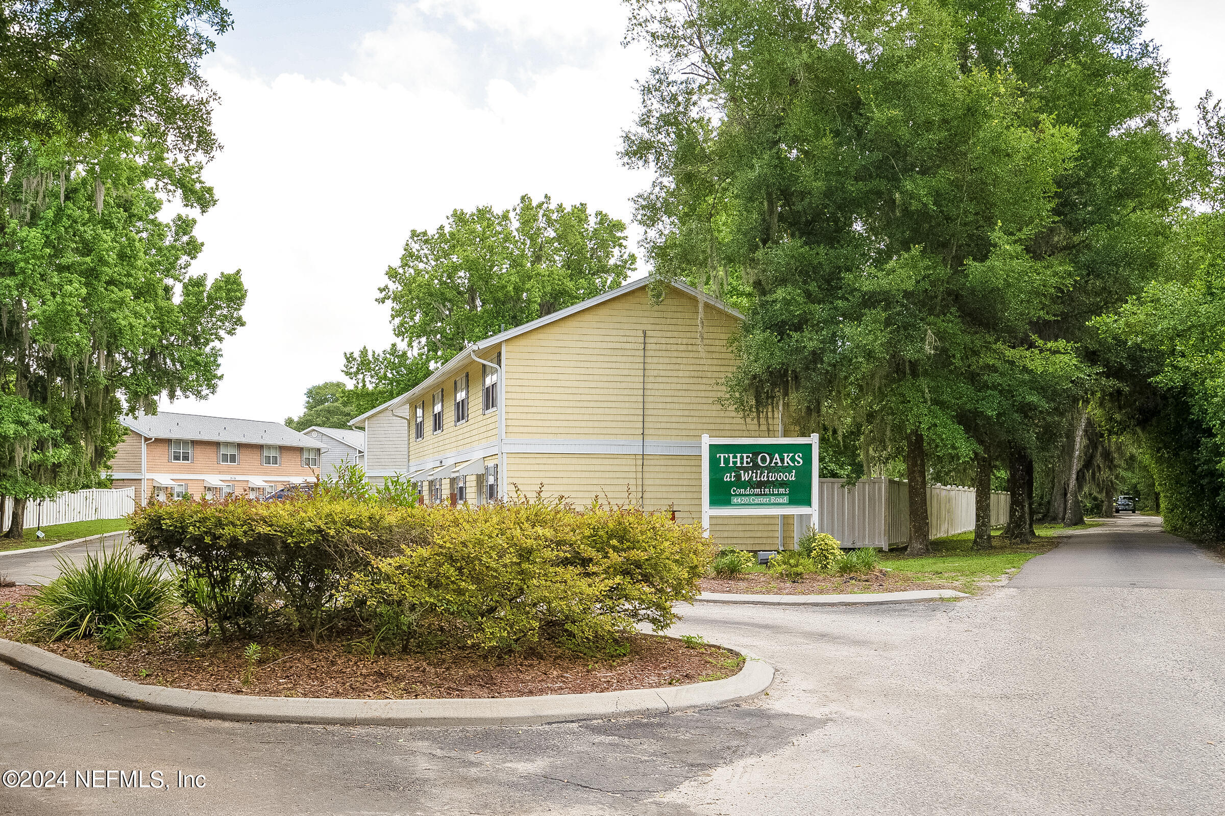 4420 Carter Road, Unit 52 St. Augustine, FL 32086 - Photo 32 of 34 a view of a house with potted plants and large trees