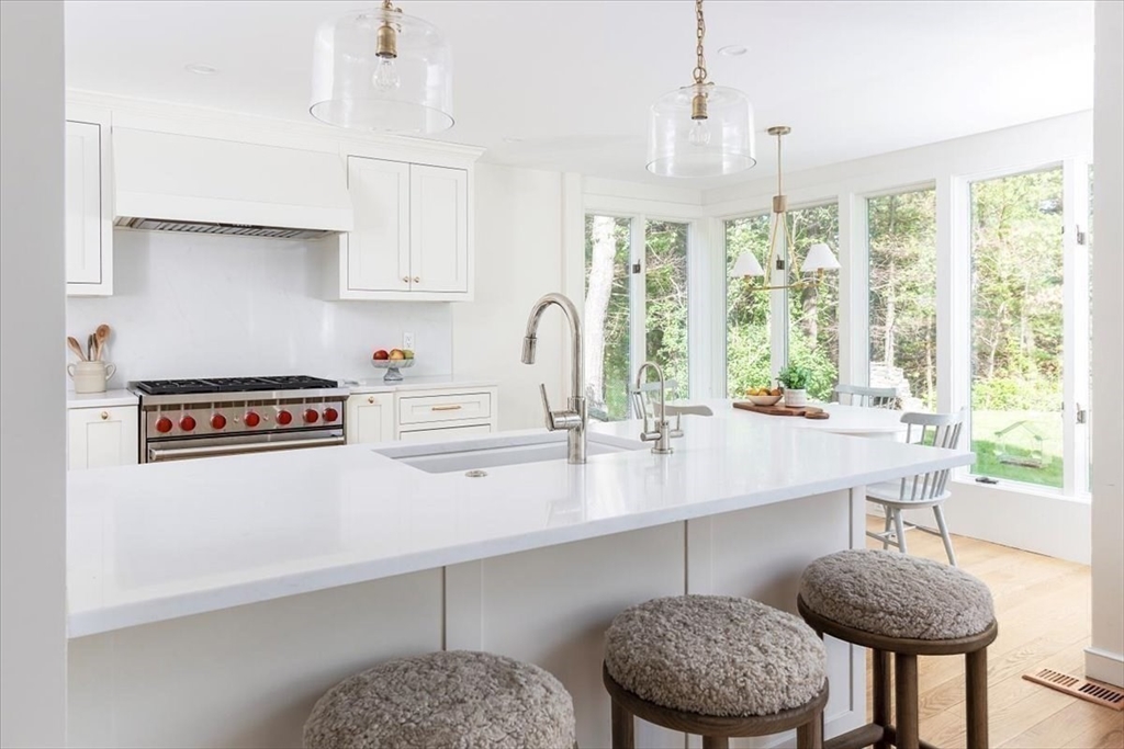 12 Meadowbrook Road Weston, MA 02493 - Photo 11 of 28 a kitchen with stainless steel appliances a table chairs and a large window