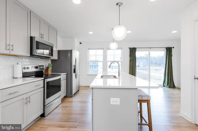 a large kitchen with stainless steel appliances granite countertop a stove a sink and a refrigerator