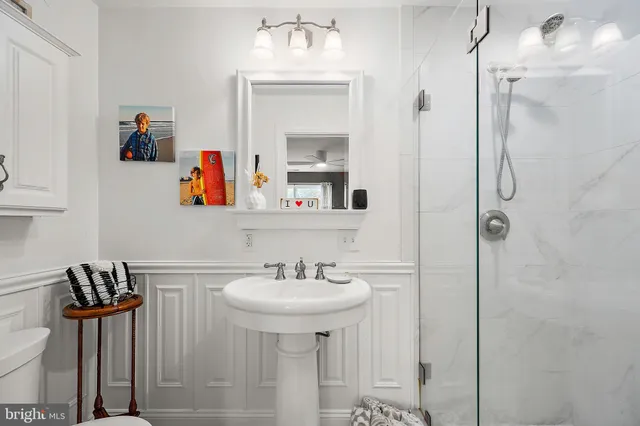 a bathroom with a sink a potted plant and a toilet