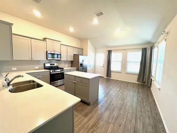 a kitchen with sink a microwave and refrigerator