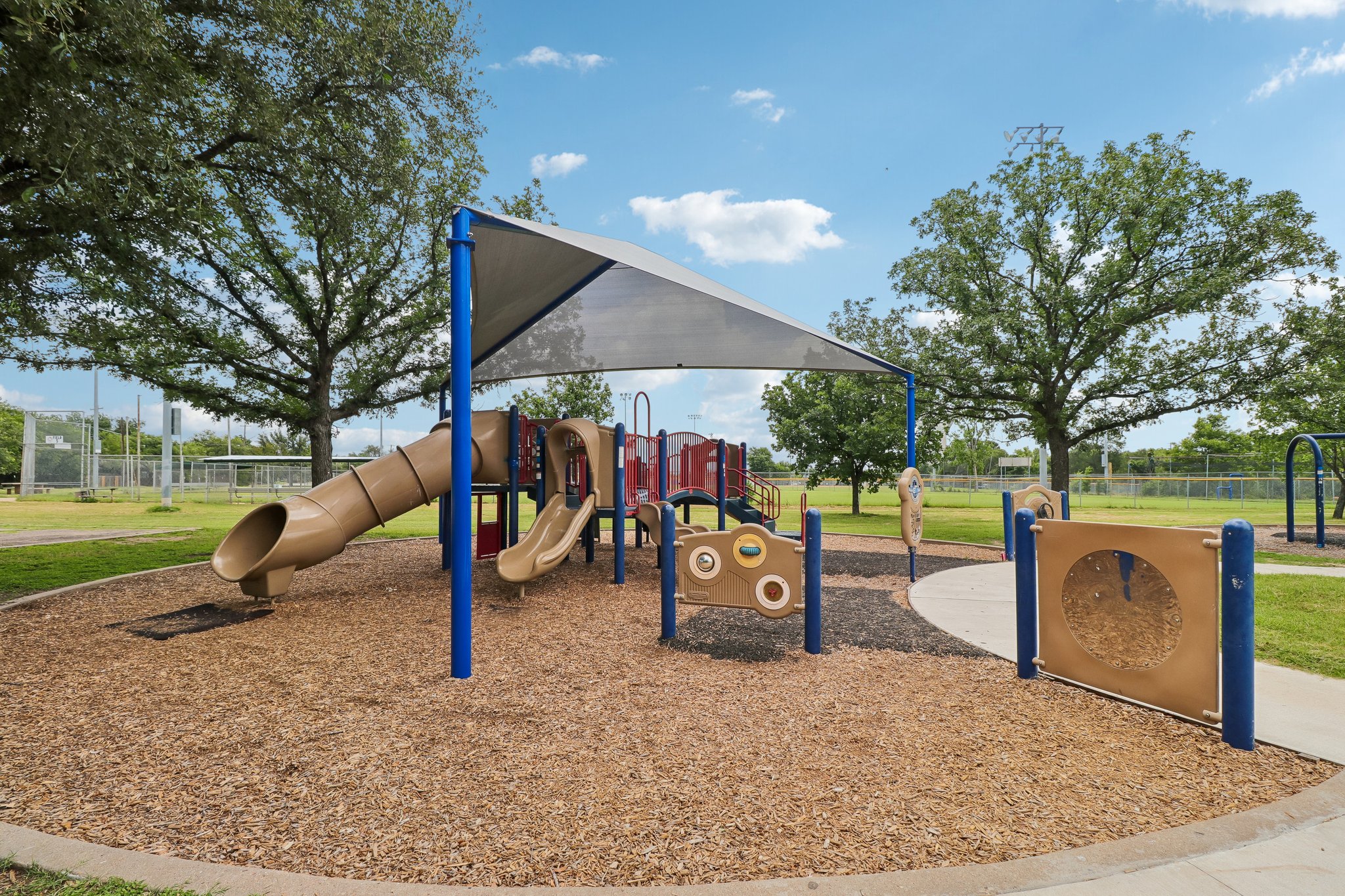 5809 Coventry Lane Austin, TX 78723 - Photo 32 of 35 A well-maintained community playground awaits, featuring shaded play structures and open green spaces for recreation.